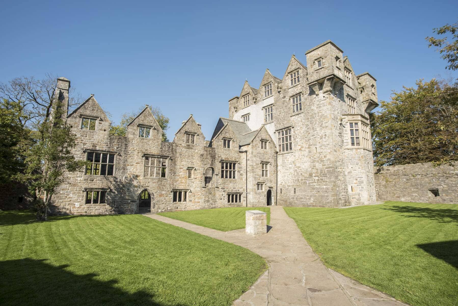 Het historische Donegal Castle in het hart van Donegal, omgeven door verzorgde gazons op een heldere dag.