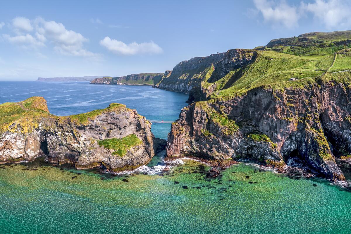 Die Carrick-a-Rede-Seilbrücke, die sich über Klippen über kristallklarem, türkisfarbenem Wasser in County Antrim spannt.