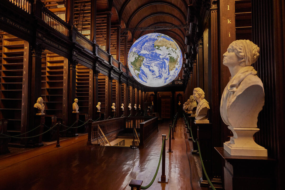 Der Long Room im Trinity College Dublin mit Büsten und einer Globusinstallation.