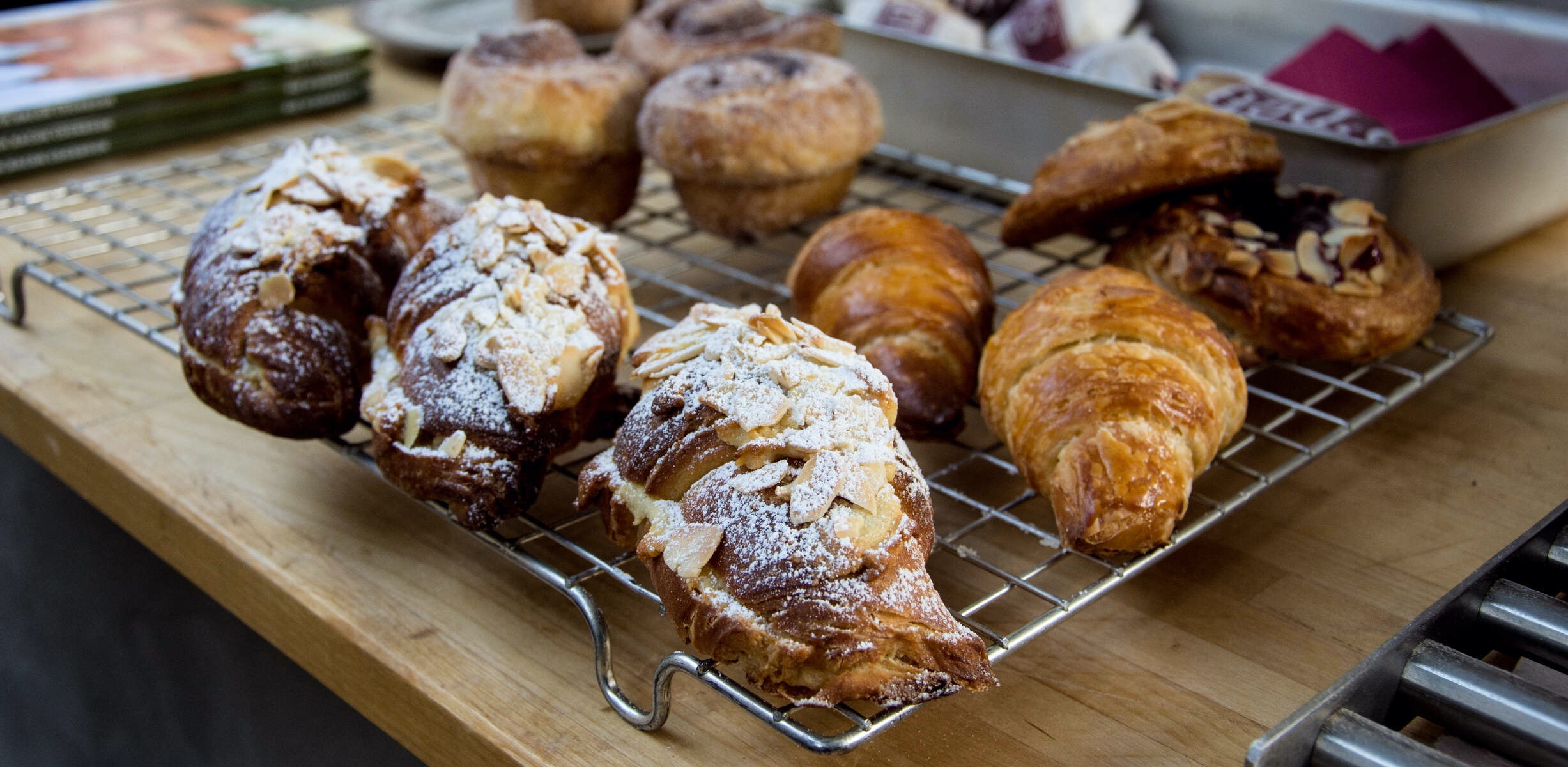 Tray of freshly baked pastries including almond croissants, cinnamon swirls, and Danish pastries displayed in Enniskillen.