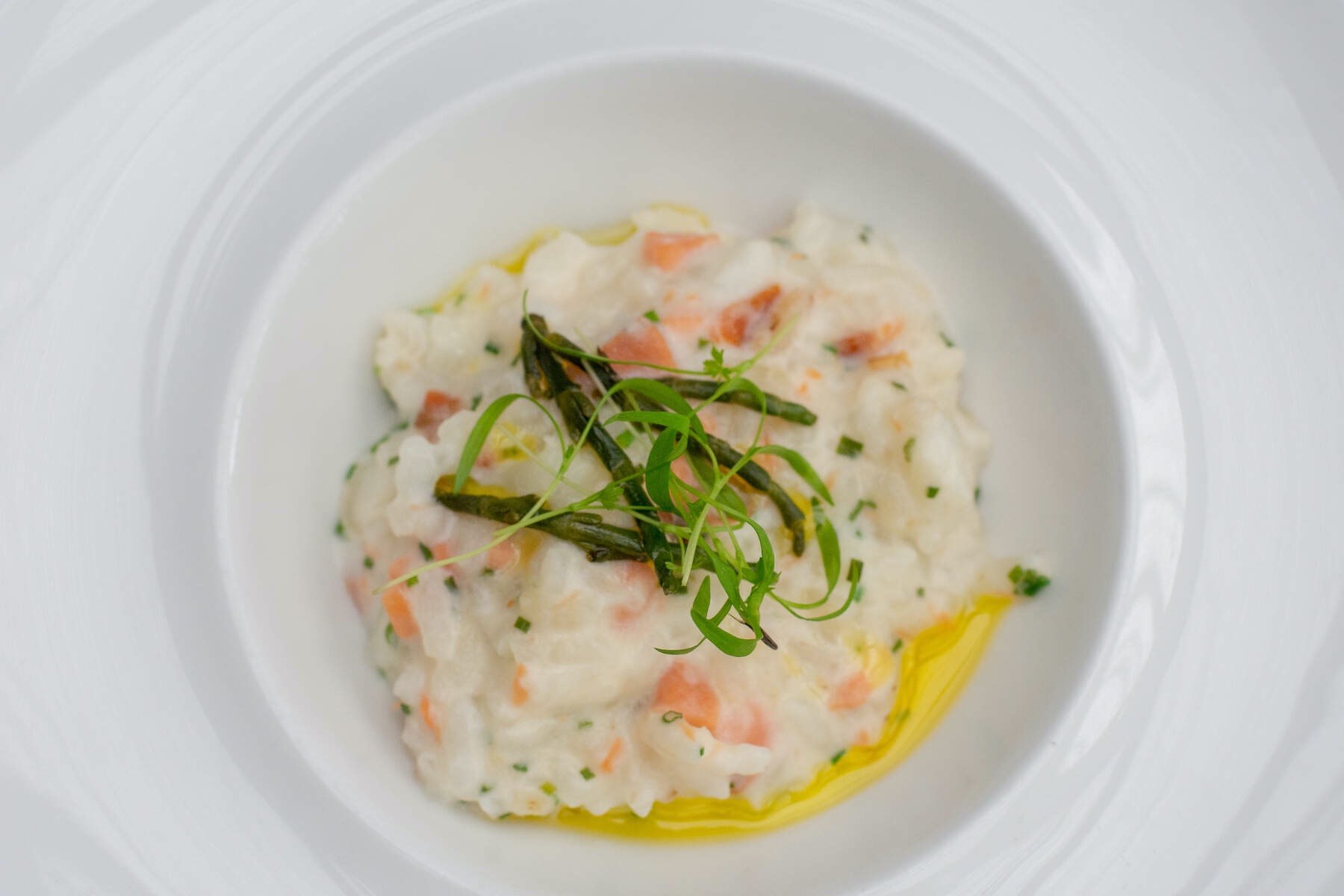 Close-up of creamy risotto dish with herbs and green garnish served on a white plate in Enniskillen restaurant.