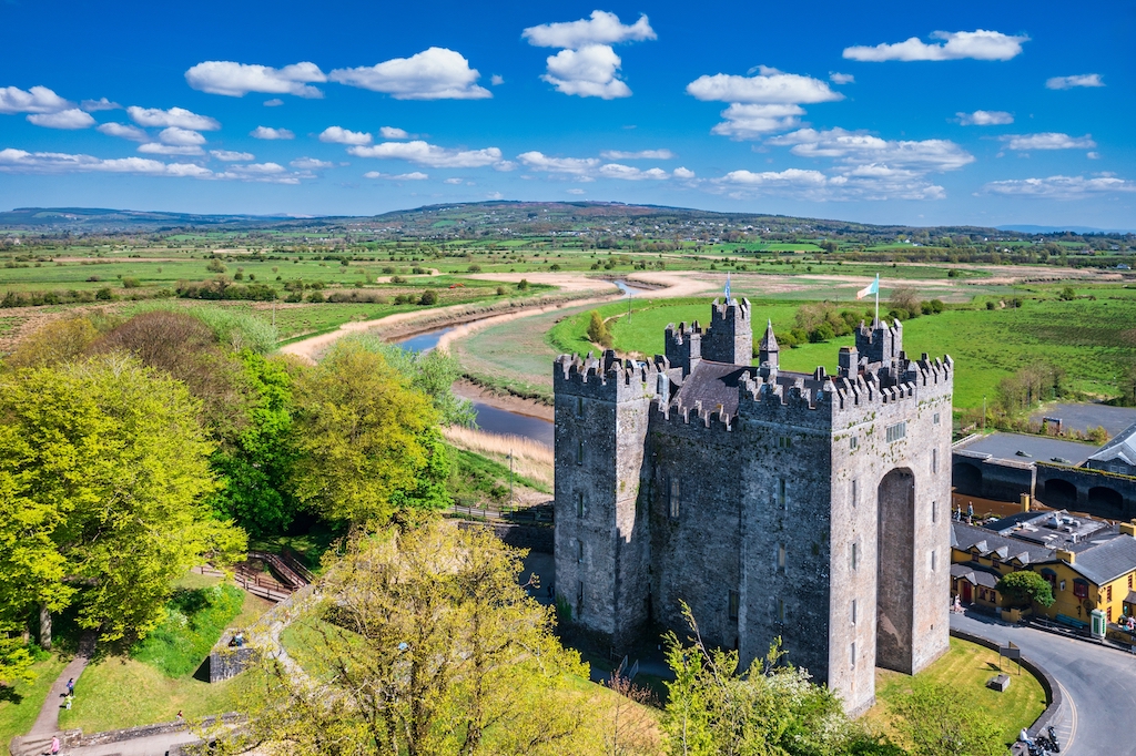 Castillo de Bunratty, situado junto al río Ratty en el condado de Clare, rodeado de un paisaje verde.