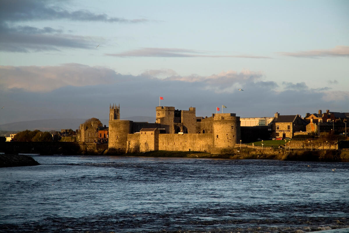 Vista del castillo del rey Juan al otro lado del río Shannon, en la ciudad de Limerick, al atardecer.