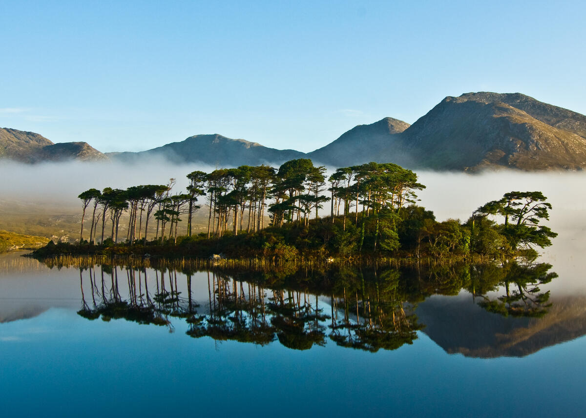 El lago Derryclare, en el que se reflejan los pinos y los Twelve Bens, en el Parque Nacional de Connemara, en el condado de Galway.