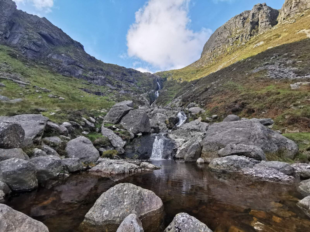 Rocky stream cascading through steep cliffs in Coumshingaun Valley, County Waterford.