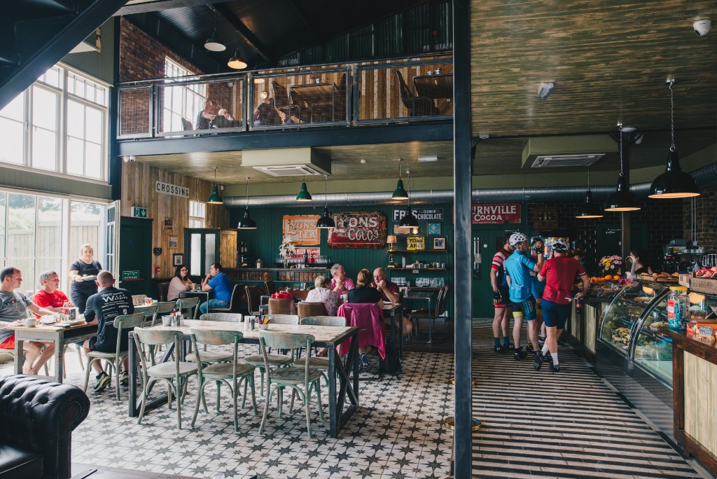 Cyclists and visitors inside a lively café along the Waterford Greenway trail.
