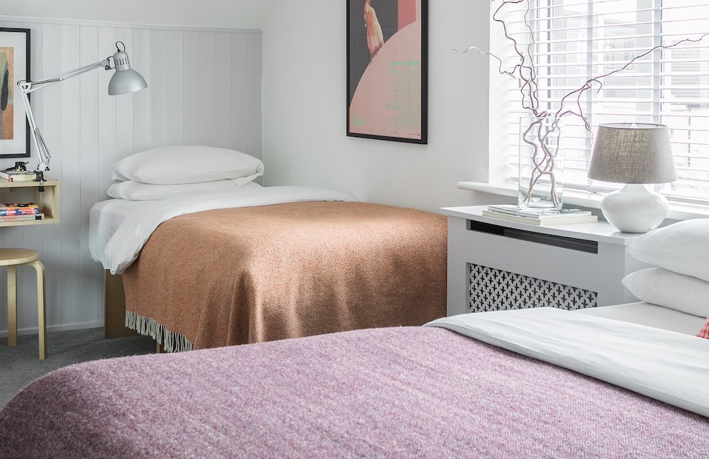 Zweibettzimmer im B&B The Stop in der Stadt Galway mit minimalistischer Einrichtung, gerahmter Kunst und in weichen Tönen gewebten Decken.
