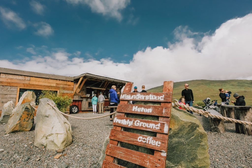 Le camion-restaurant Misunderstood Heron dans le comté de Galway avec des visiteurs faisant la queue sur fond de collines.