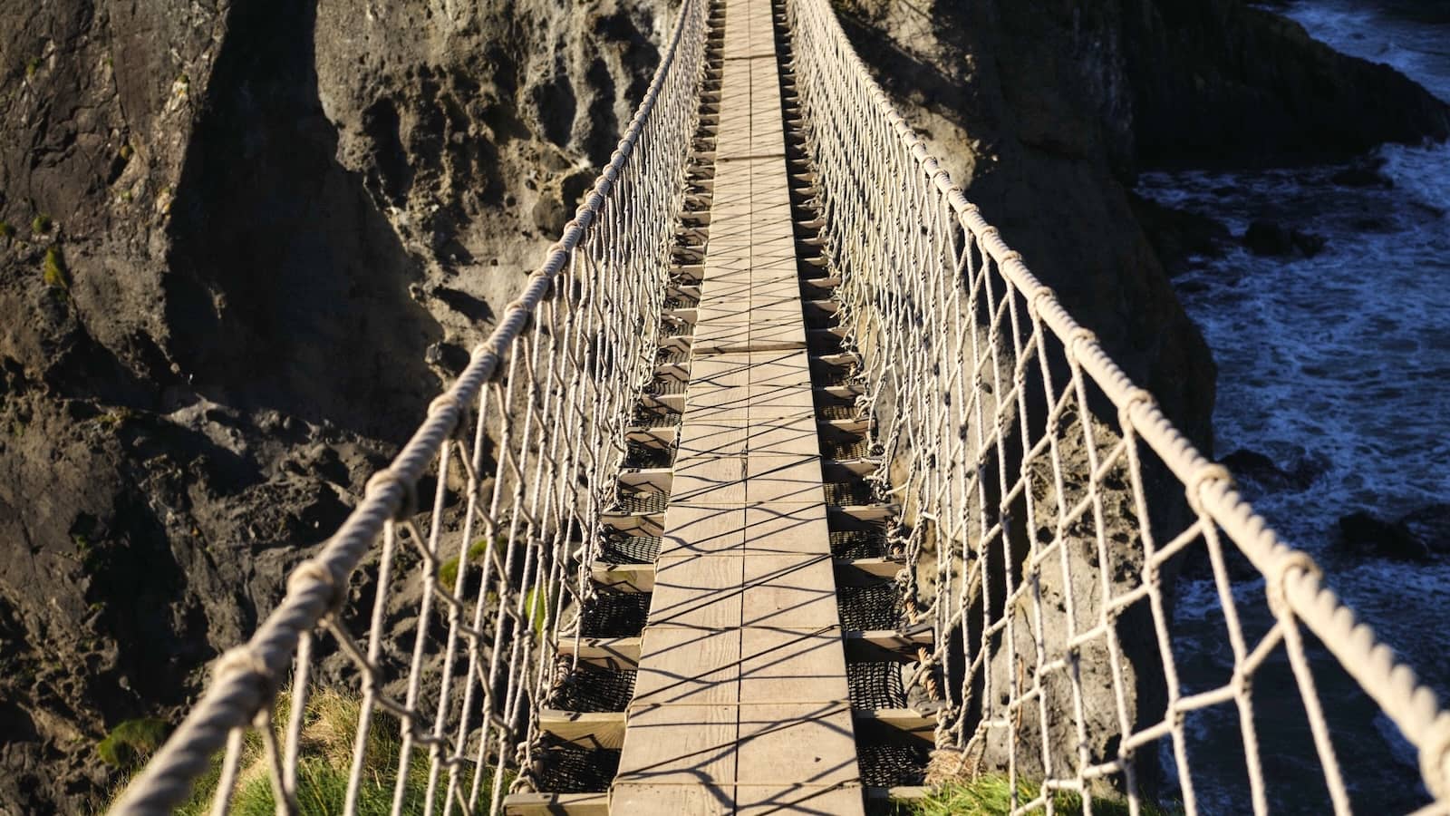 Carrick-a-Rede rope bridge stretching across a rocky chasm above the Atlantic Ocean in County Antrim.