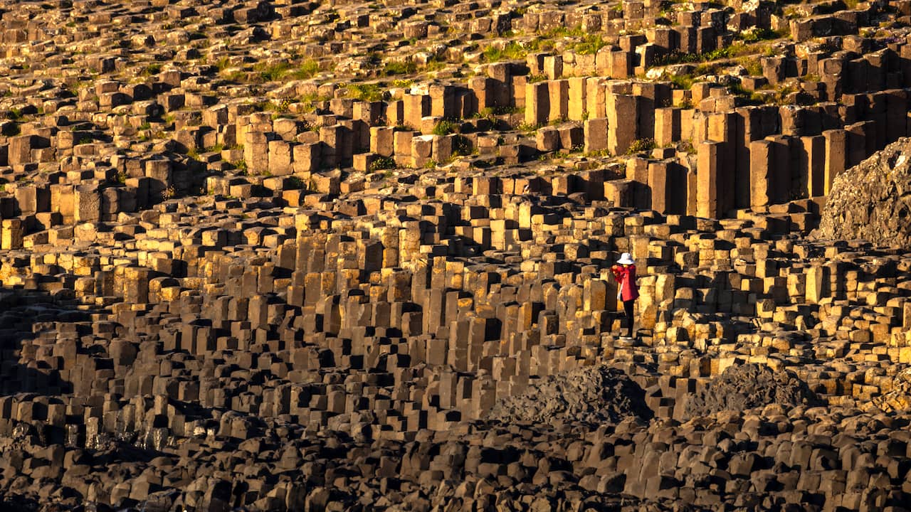 Visitor standing among the basalt columns of the Giant's Causeway on the Causeway Coast, County Antrim.