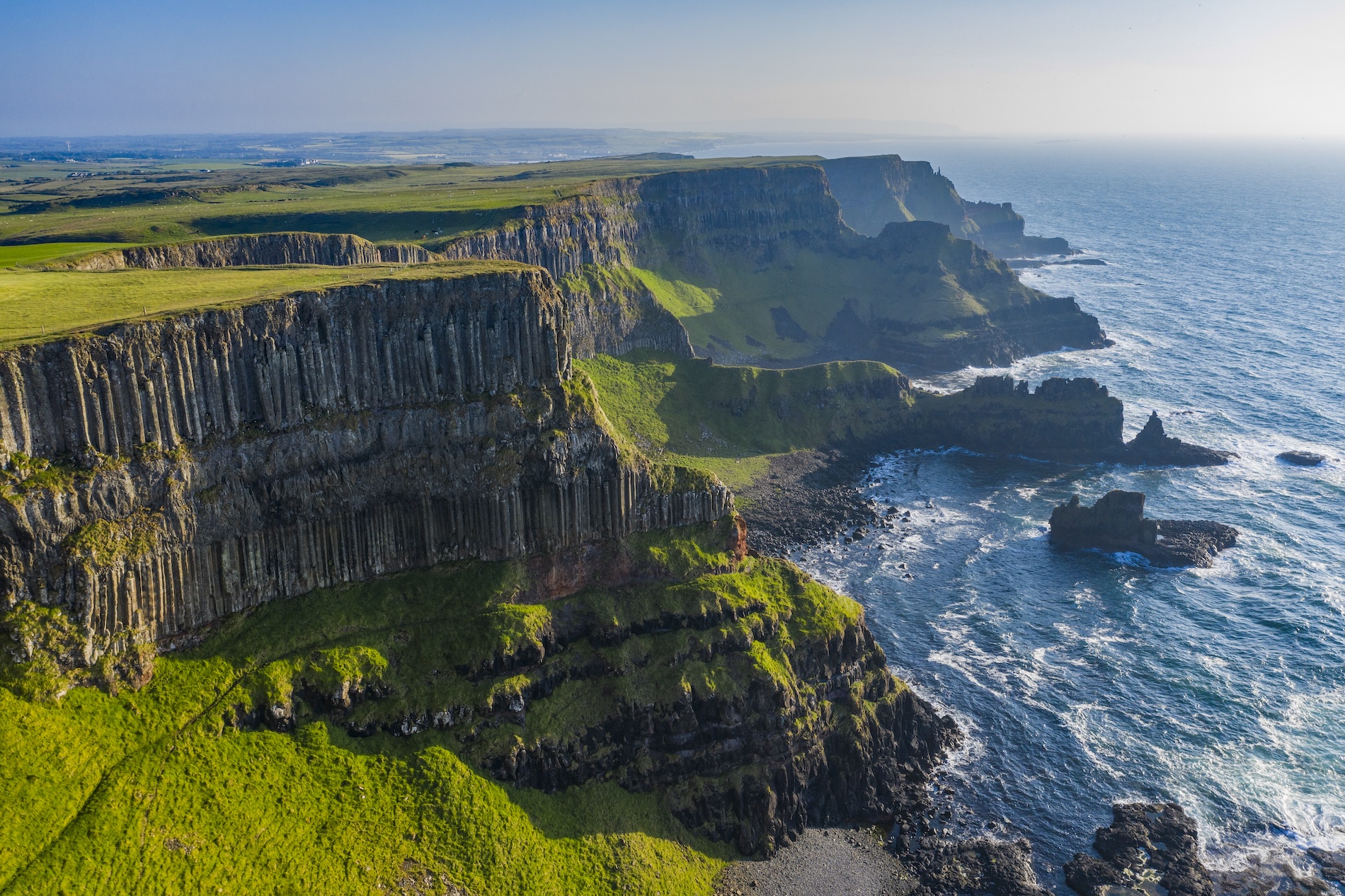 Aerial view of the rugged cliffs of the Causeway Coast, carved by time and sea in Northern Ireland.