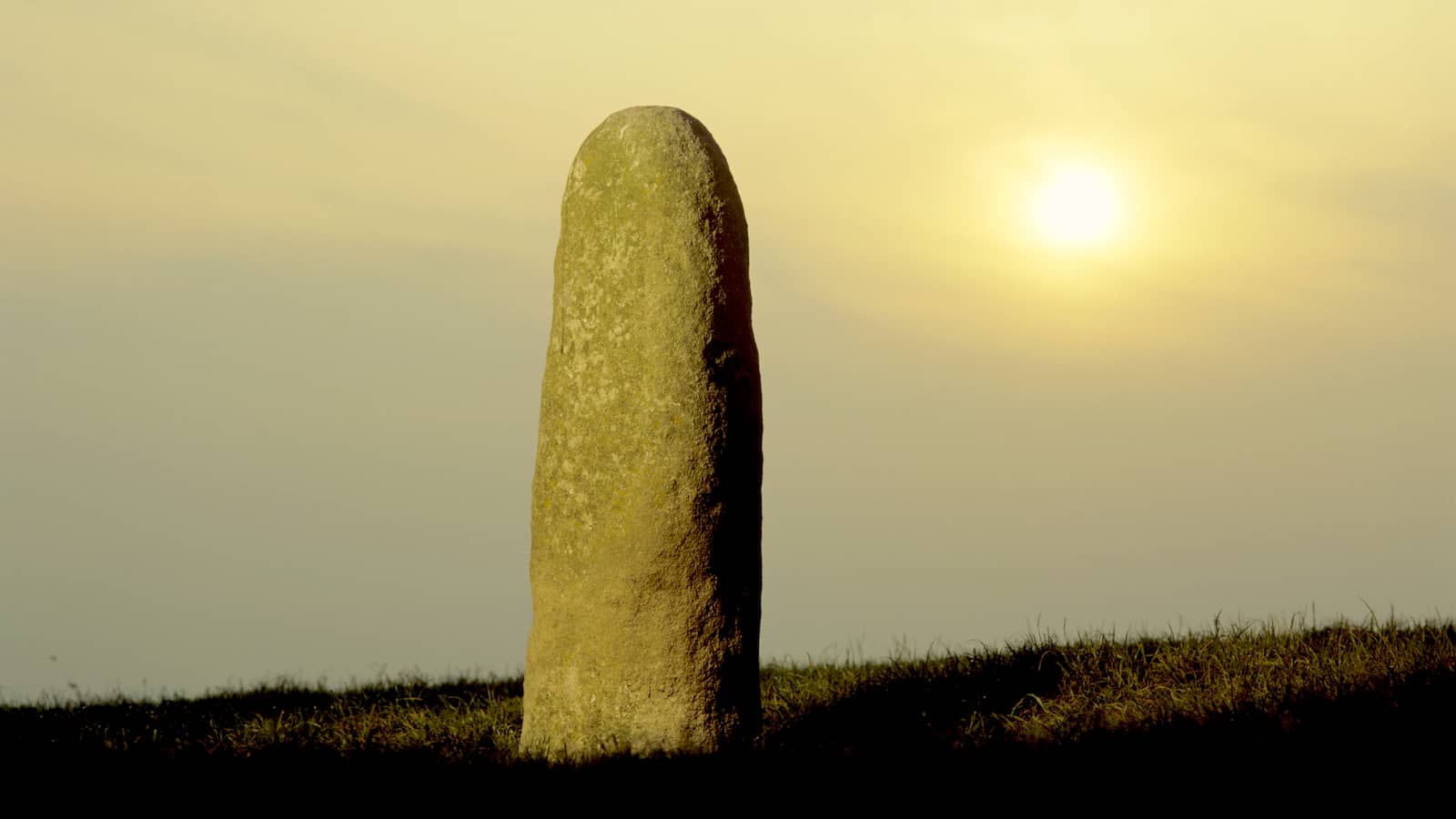 Lia Fáil, the Stone of Destiny, standing on the Hill of Tara in County Meath at sunset.
