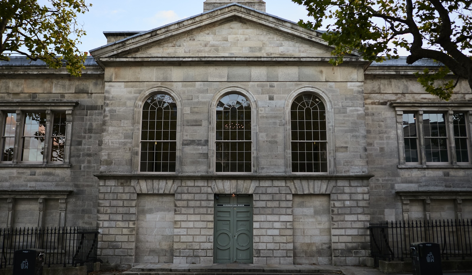 Exterior of Kilmainham Gaol Museum, Dublin, with neoclassical stone façade and arched windows.