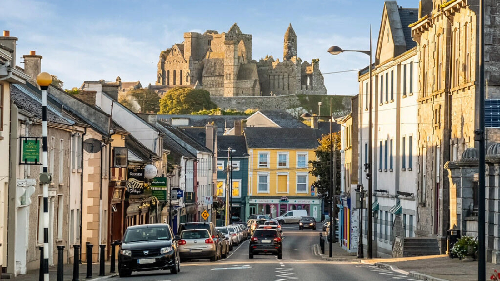 Vista de una calle de la ciudad de Cashel con las ruinas de la Roca de Cashel en la colina del condado de Tipperary