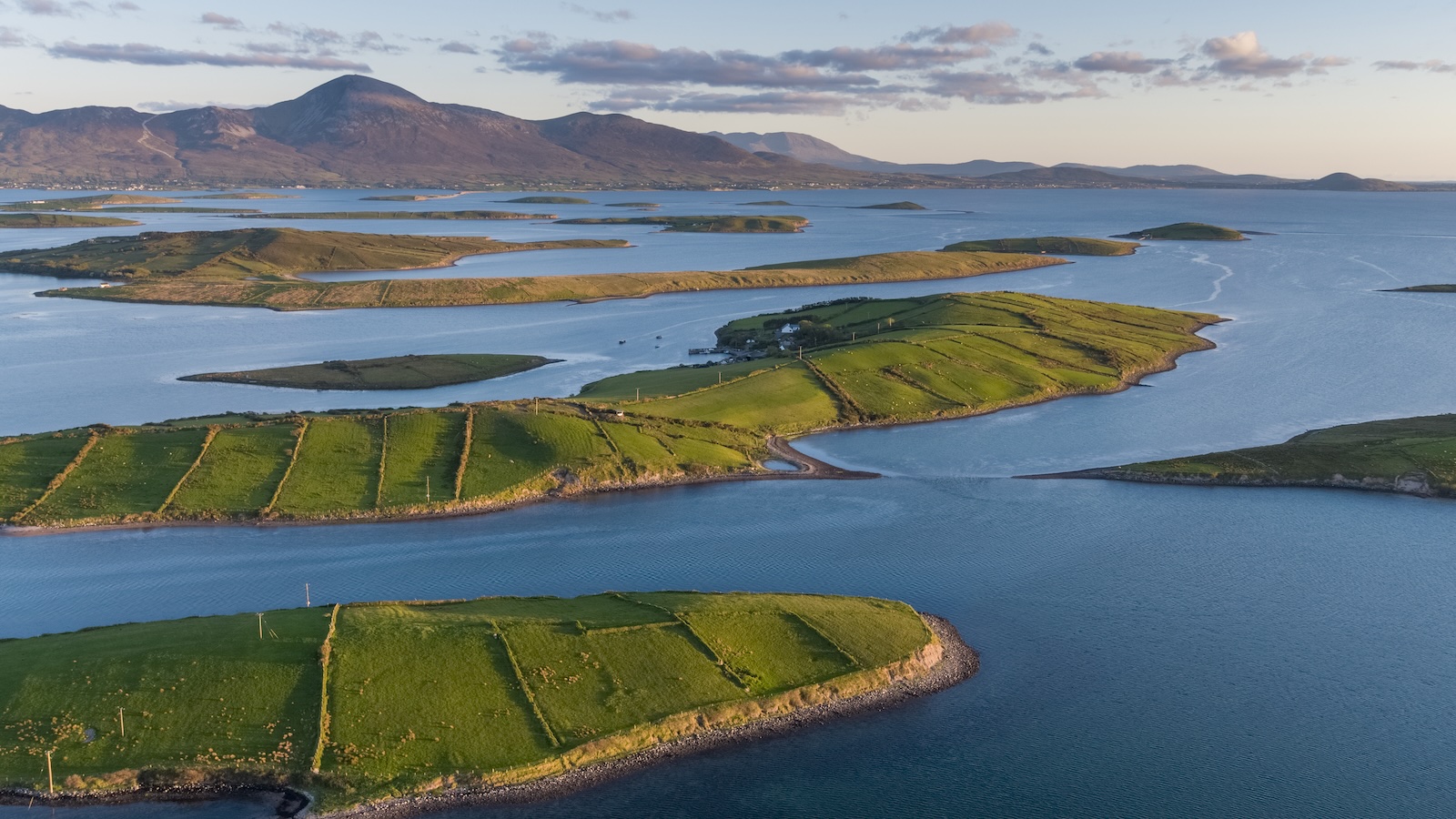 Vista aérea de las islas verdes de la bahía de Clew con Croagh Patrick al fondo al atardecer.