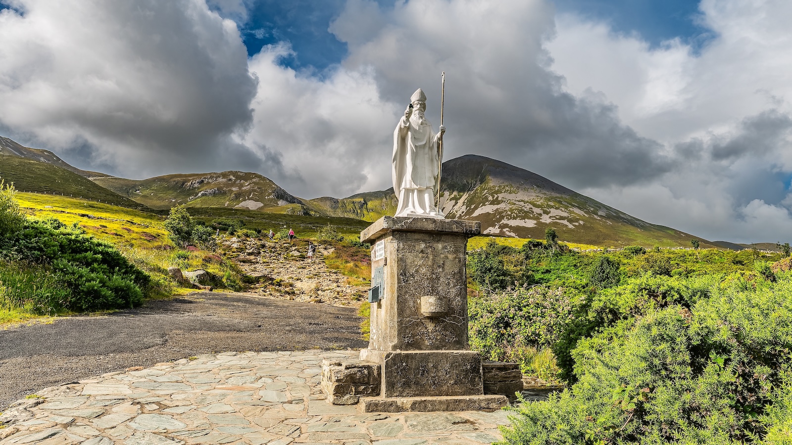 Estatua de San Patricio al pie del Croagh Patrick, con las escarpadas montañas al fondo.