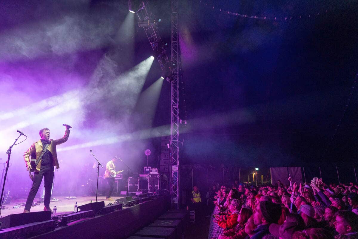 Live music performance on a smoke-filled stage with purple lighting, as a crowd watches at the Púca Festival in Meath.