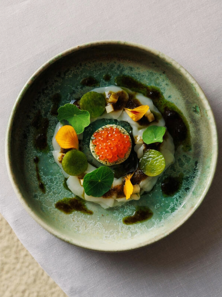 Fine dining seafood dish with edible flowers and roe served in a ceramic bowl at Gregans Castle Hotel, County Clare.