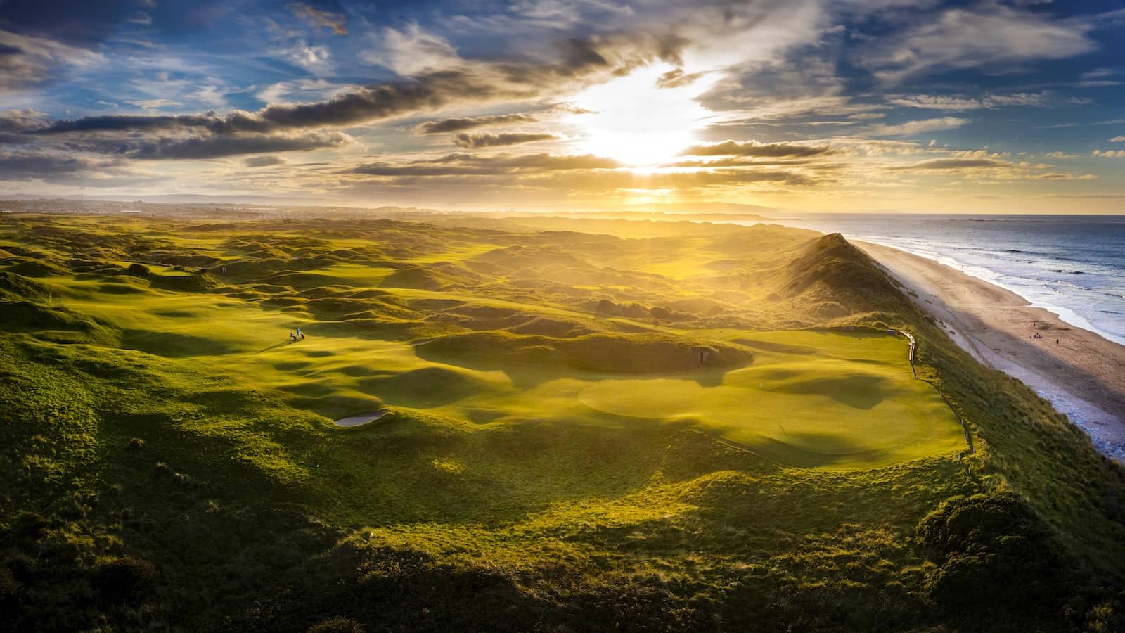 Le Royal Portrush Golf Club dans le comté d'Antrim avec des parcours côtiers et le phare sur la côte atlantique.