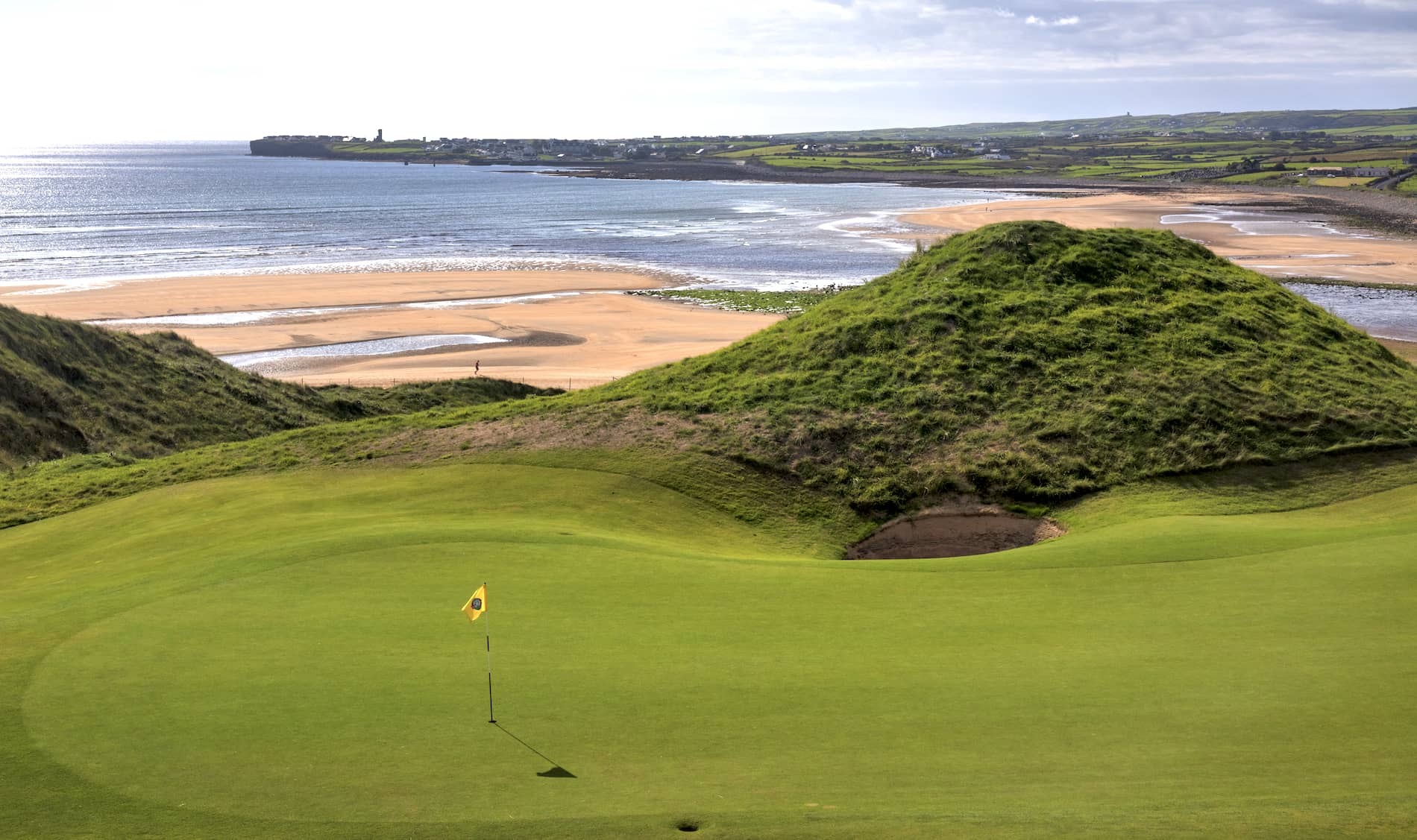 Golf green surrounded by towering sand dunes at Lahinch Golf Club in County Clare.
