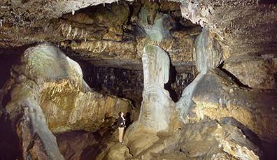 Formaciones de piedra caliza en el interior de la cueva de Dunmore con una persona explorándola, Kilkenny.