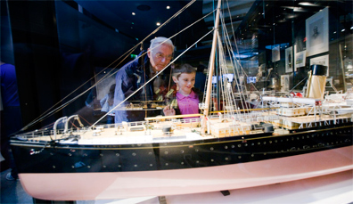 Visitatore e bambino che guardano un modello dettagliato del RMS Titanic al Museo dei Trasporti dell'Ulster, nella contea di Down.