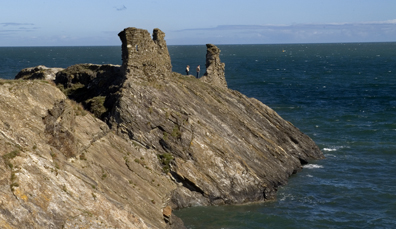 Remnants of the coastal Black Castle stand atop a sloped rocky headland overlooking the sea in Wicklow.