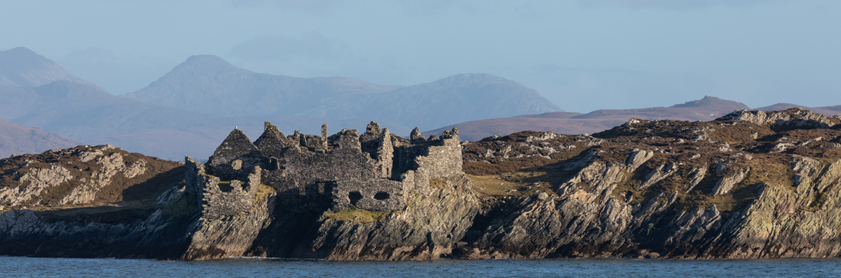 Ruinen einer steinernen Burg, die an der felsigen Küste einer Insel in der Nähe von Inishbofin entlang der Atlantikküste von Galway stehen.