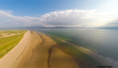 Luftbild von Inch Strand in der Grafschaft Kerry, Irland, mit einem langen Sandstrand und den sich bis zum Horizont erstreckenden Gewässern des Atlantiks.
