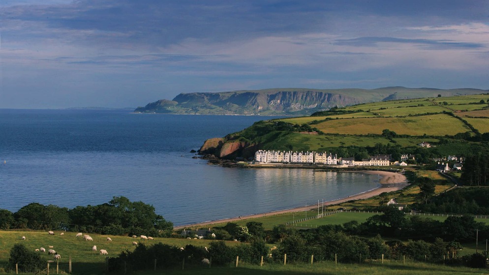 Vista de Cushendun, un pueblo costero situado entre acantilados, el mar y exuberantes campos verdes en el condado de Antrim.