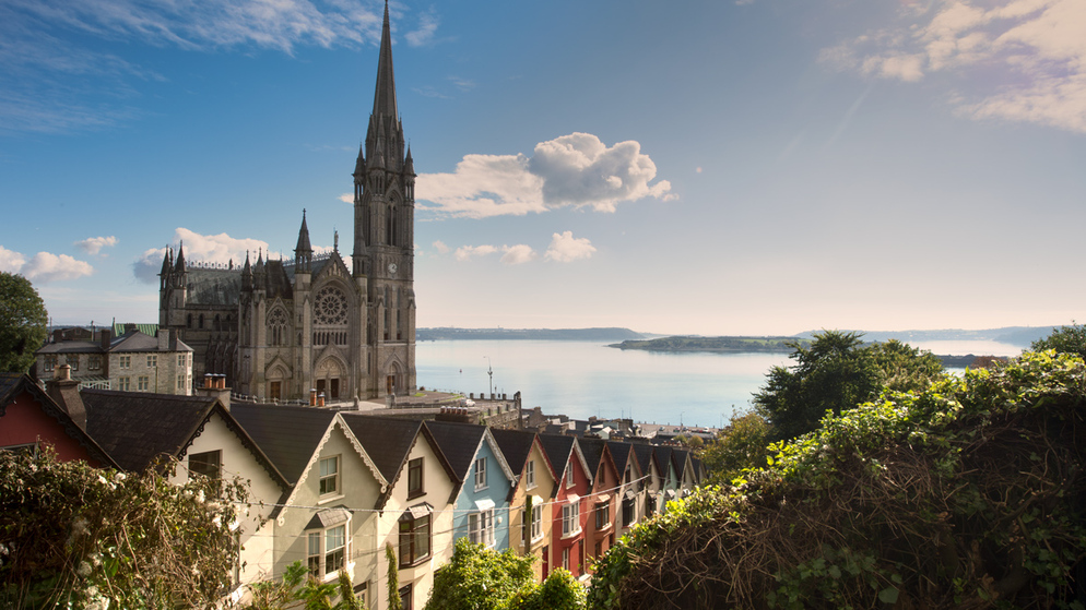 Kleurrijke havenhuizen en de St. Colman's Kathedraal met uitzicht op Cobh, county Cork.