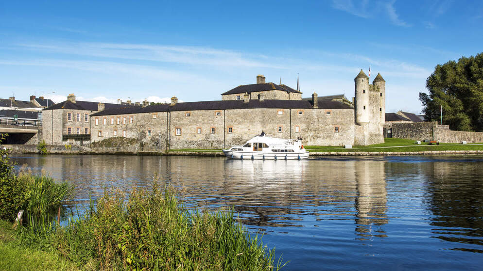 Cruiser boat on the River Erne near Enniskillen Castle in County Fermanagh on a sunny day.