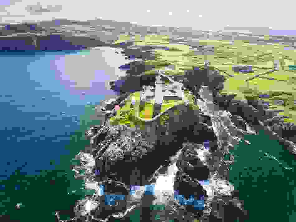 Fanad Head Lighthouse on rocky peninsula surrounded by Atlantic Ocean in County Donegal.