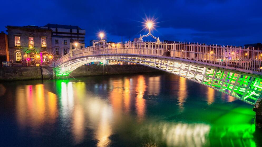 Una scena di strada serale vivace, animata nel Temple Bar di Dublinocon persone che cenano all'aperto sotto lucine.