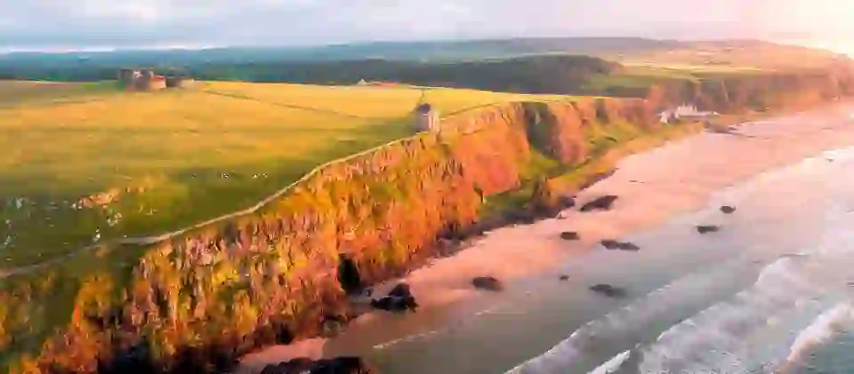 Panoramic sunset view of Mussenden Temple and Downhill Beach along the Causeway Coastal Route, County Londonderry.