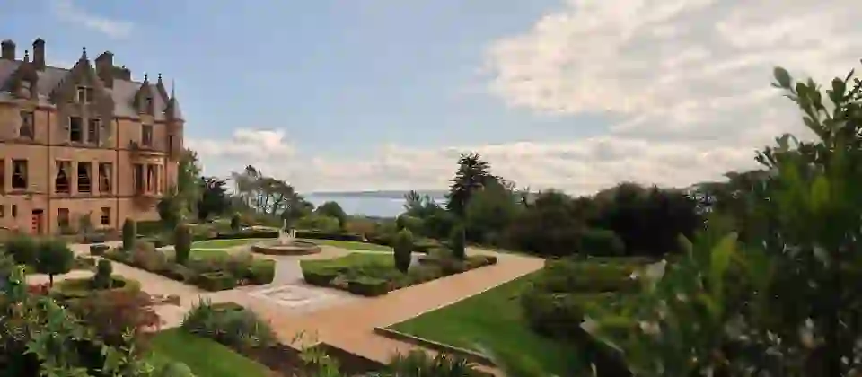 Belfast Castle and formal gardens with fountain overlooking Belfast Lough, County Antrim.