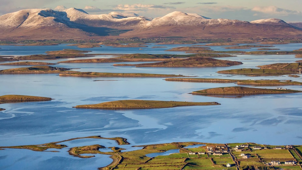 Clew Bay’s drumlin islands and snow-dusted mountains stretch across the landscape in County Mayo.