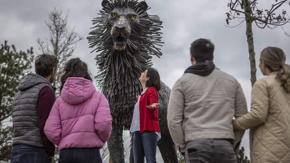 Visitors look up at towering Aslan sculpture in CS Lewis Square, Belfast, inspired by The Chronicles of Narnia.
