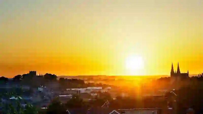 Sunset over Armagh city, with cathedral spires rising above rooftops and countryside.