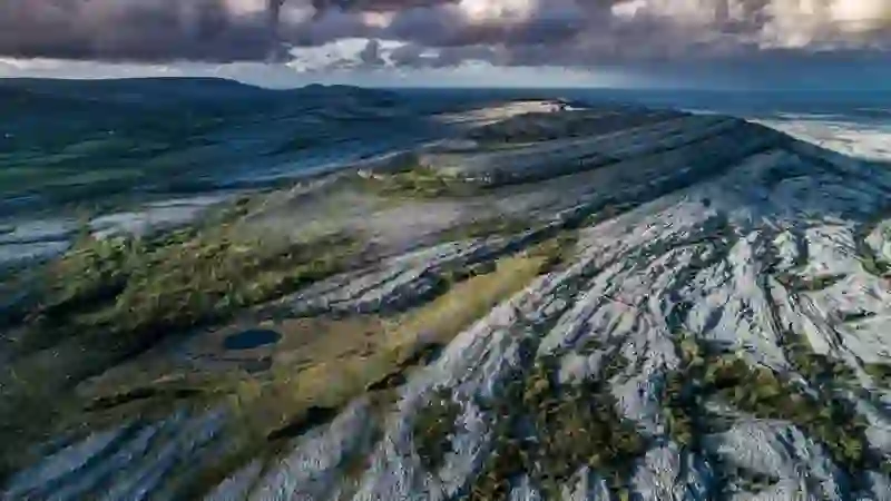 Aerial view of the Burren, County Clare, showing limestone pavements, rolling hills and the Atlantic coast.