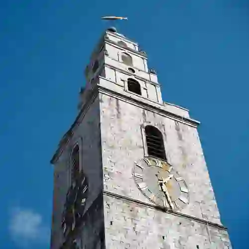 Shandon Bells klokkentoren in Cork, een historisch herkenningspunt met een windvaan in de vorm van een vis tegen een strakblauwe hemel.