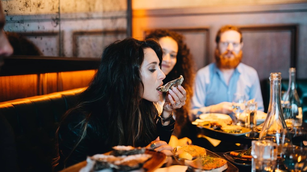 People enjoying oysters and local food in Cork restaurant, showcasing the city’s renowned food scene.