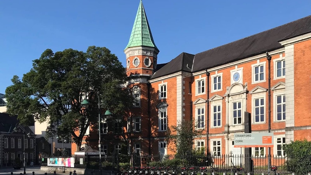 Crawford Art Gallery in Cork City, redbrick building with tower and bicycles lined outside entrance.