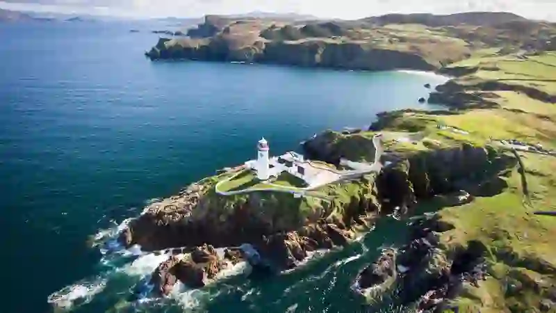 Fanad Head Lighthouse on rocky cliffs overlooking the Atlantic coast in County Donegal.