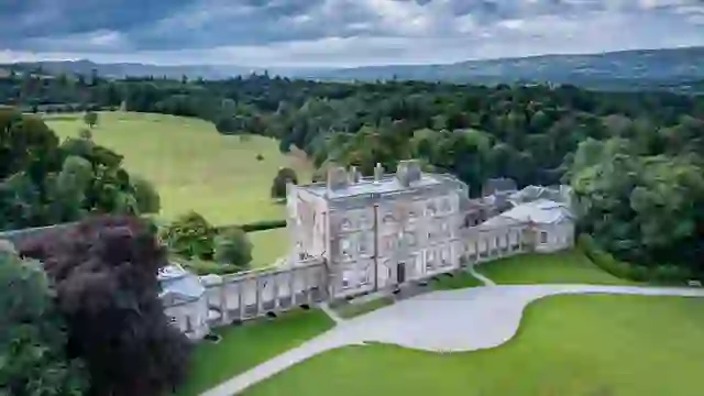Vista aérea de la mansión y el parque de Florence Court, rodeado de bosques bajo el cielo del condado de Fermanagh.