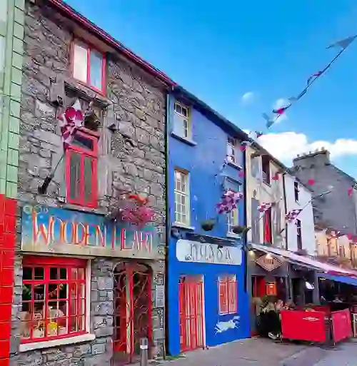 Devantures colorées de Quay Street, à Galway, avec guirlandes de fanions, cafés et bâtiments traditionnels en pierre.