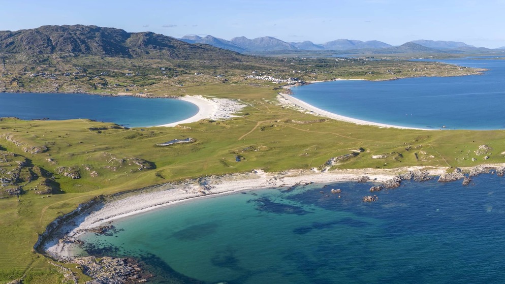 Aerial view of a curved white-sand beach and turquoise waters along the Connemara coast in Galway.
