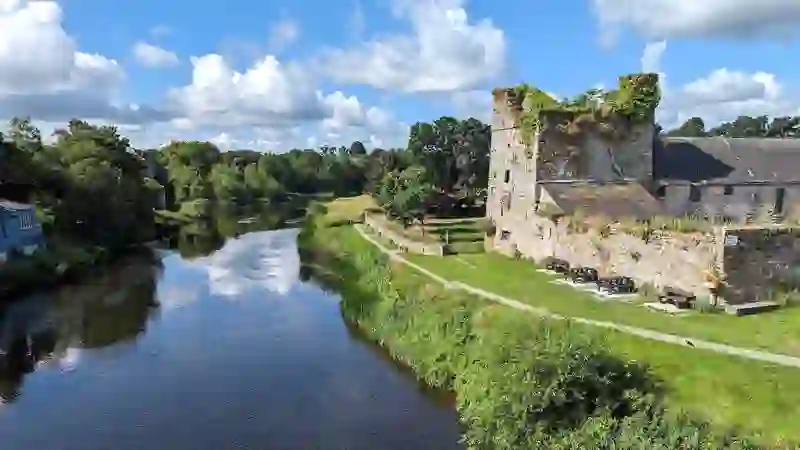 Château de Sweetman bordant la rivière Nore, avec sentier fluvial et espaces verts à Kilkenny.