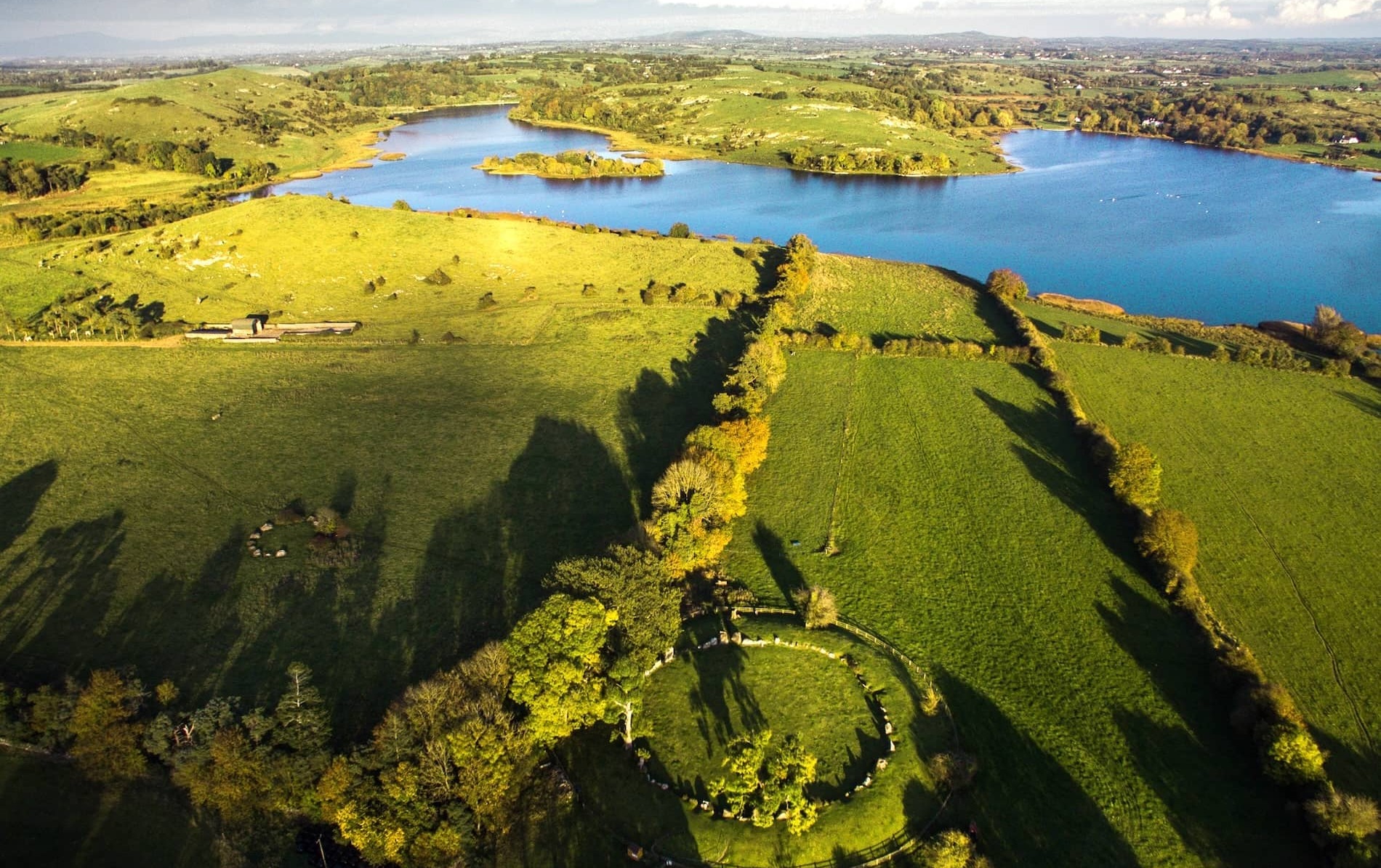Lough Gur, County Limerick, with lake, green fields and ancient stone circle in scenic countryside.