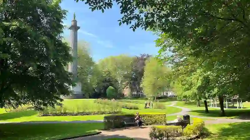 People relaxing in People’s Park beside the O’Connell Monument in Limerick city on a sunny day.